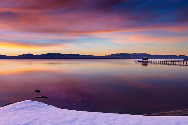 Beach in sunset in the winter with snow on the ground