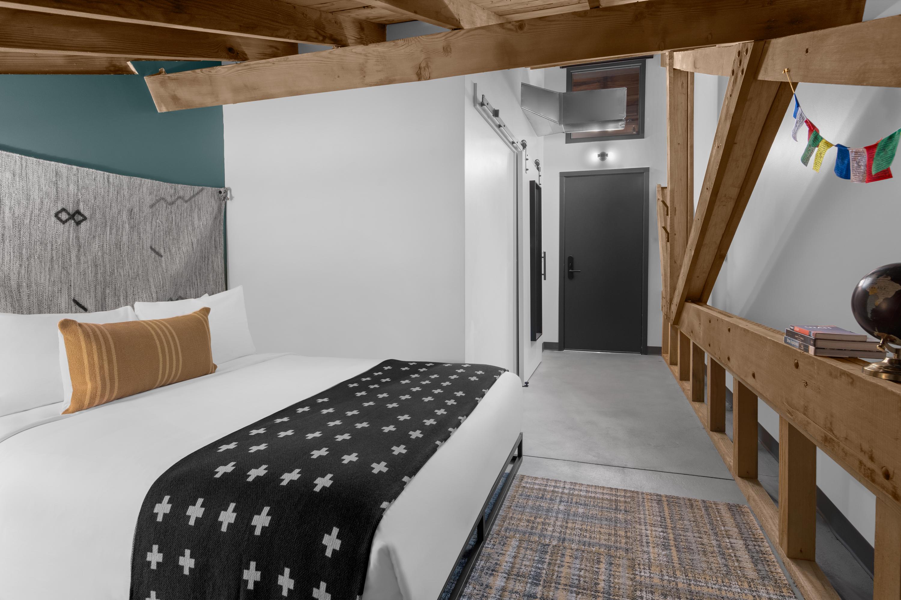 Room with queen bed and exposed wooden beams