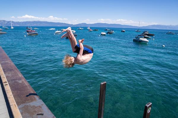 Person doing a back flip off of a dock